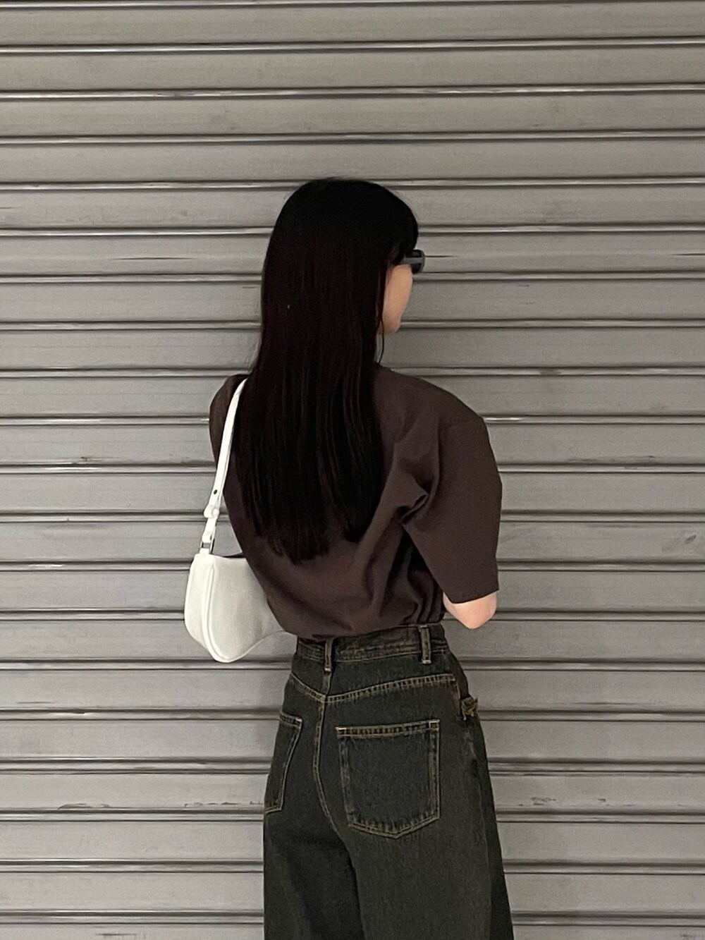 ブラウン系のTシャツ/カットソー、ブルー系のデニムパンツ、ホワイト系のパンプスを着用したレディースの春コーディネートの6枚目の写真