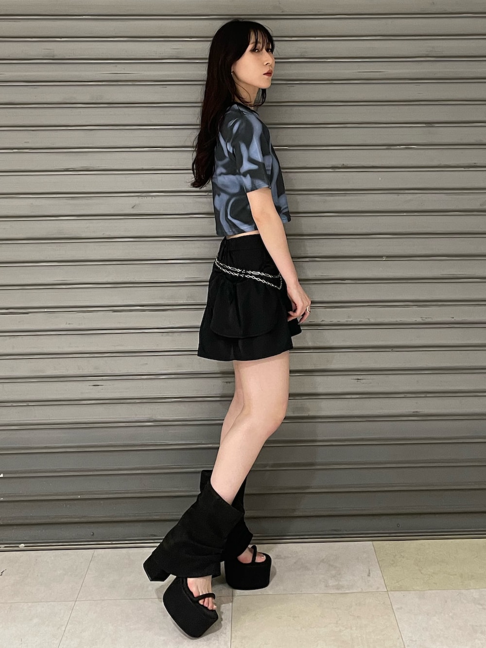 ブルー系のTシャツ/カットソー、ブラック系のスカート、ブラック系のサンダルを着用したレディースの夏コーディネートの2枚目の写真