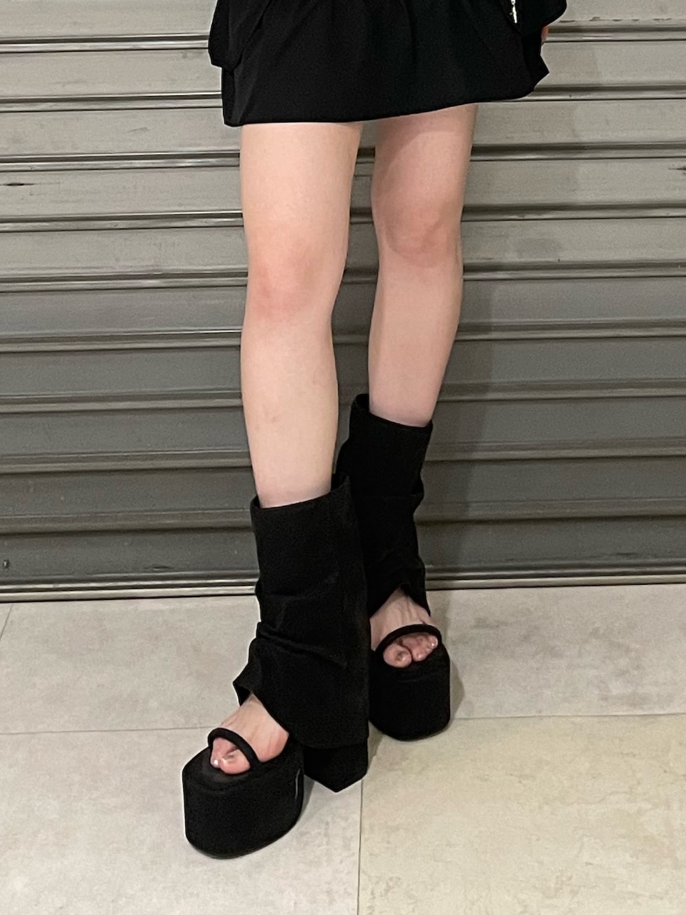 ブルー系のTシャツ/カットソー、ブラック系のスカート、ブラック系のサンダルを着用したレディースの夏コーディネートの6枚目の写真