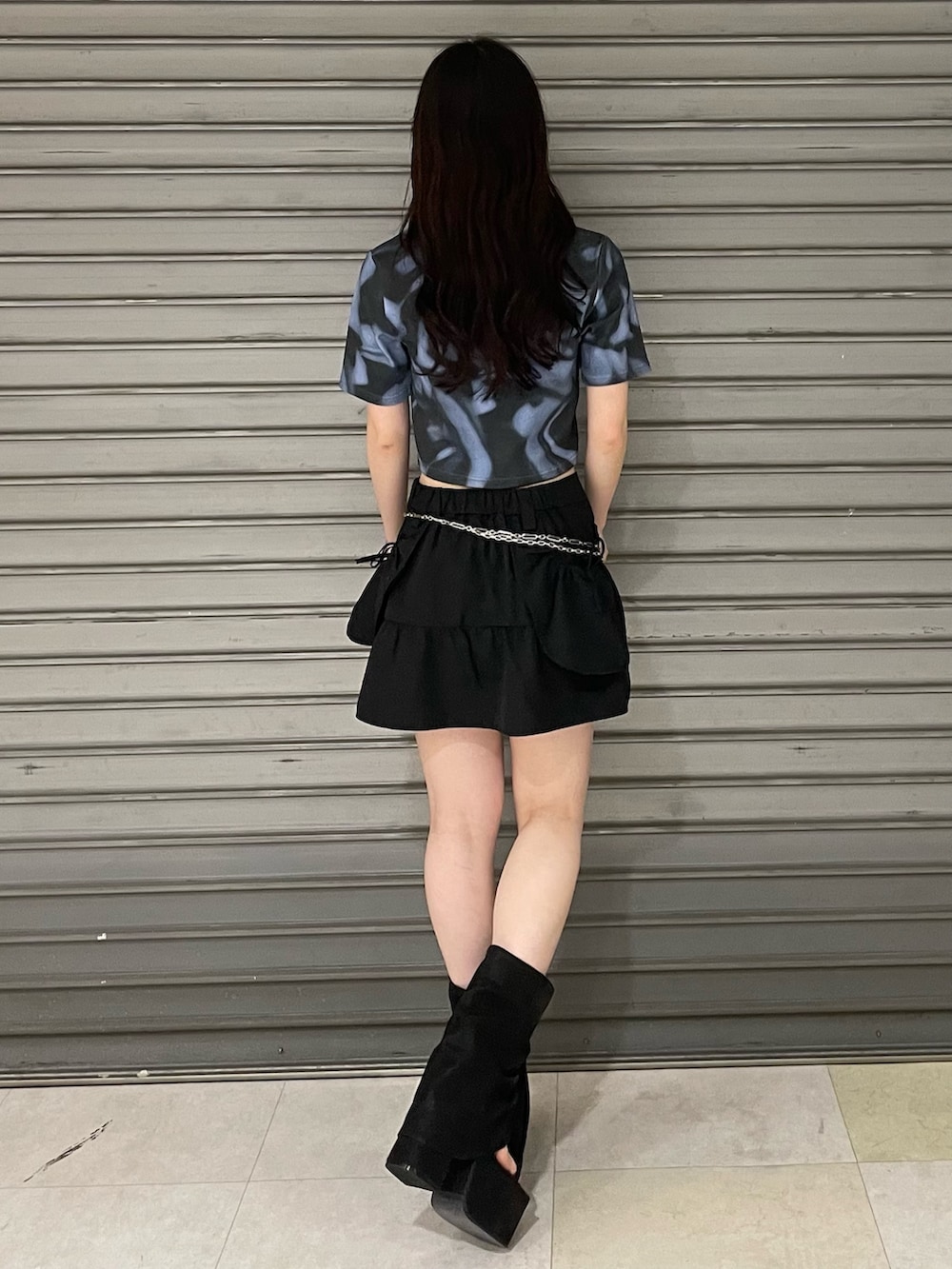 ブルー系のTシャツ/カットソー、ブラック系のスカート、ブラック系のサンダルを着用したレディースの夏コーディネートの3枚目の写真