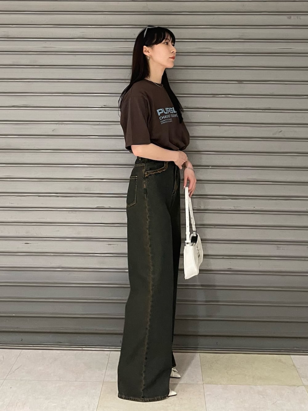 ブラウン系のTシャツ/カットソー、ブルー系のデニムパンツ、ホワイト系のパンプスを着用したレディースの春コーディネートの3枚目の写真