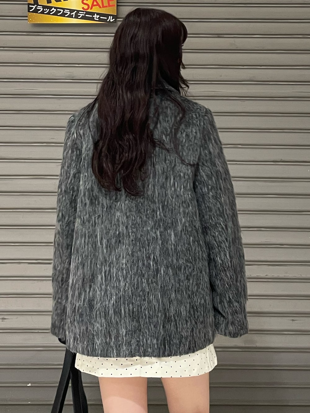 ブラック系のニット/セーター、グレー系のその他アウター、ホワイト系のスカートを着用したレディースの冬コーディネートの5枚目の写真