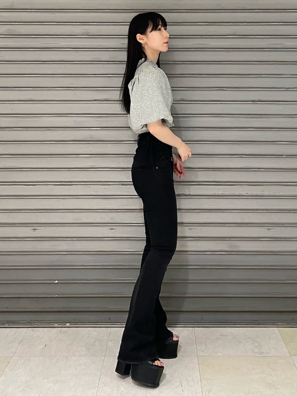 グレー系のTシャツ/カットソー、ブラック系のデニムパンツ、ブラック系のサンダルを着用したレディースの春コーディネートの3枚目の写真