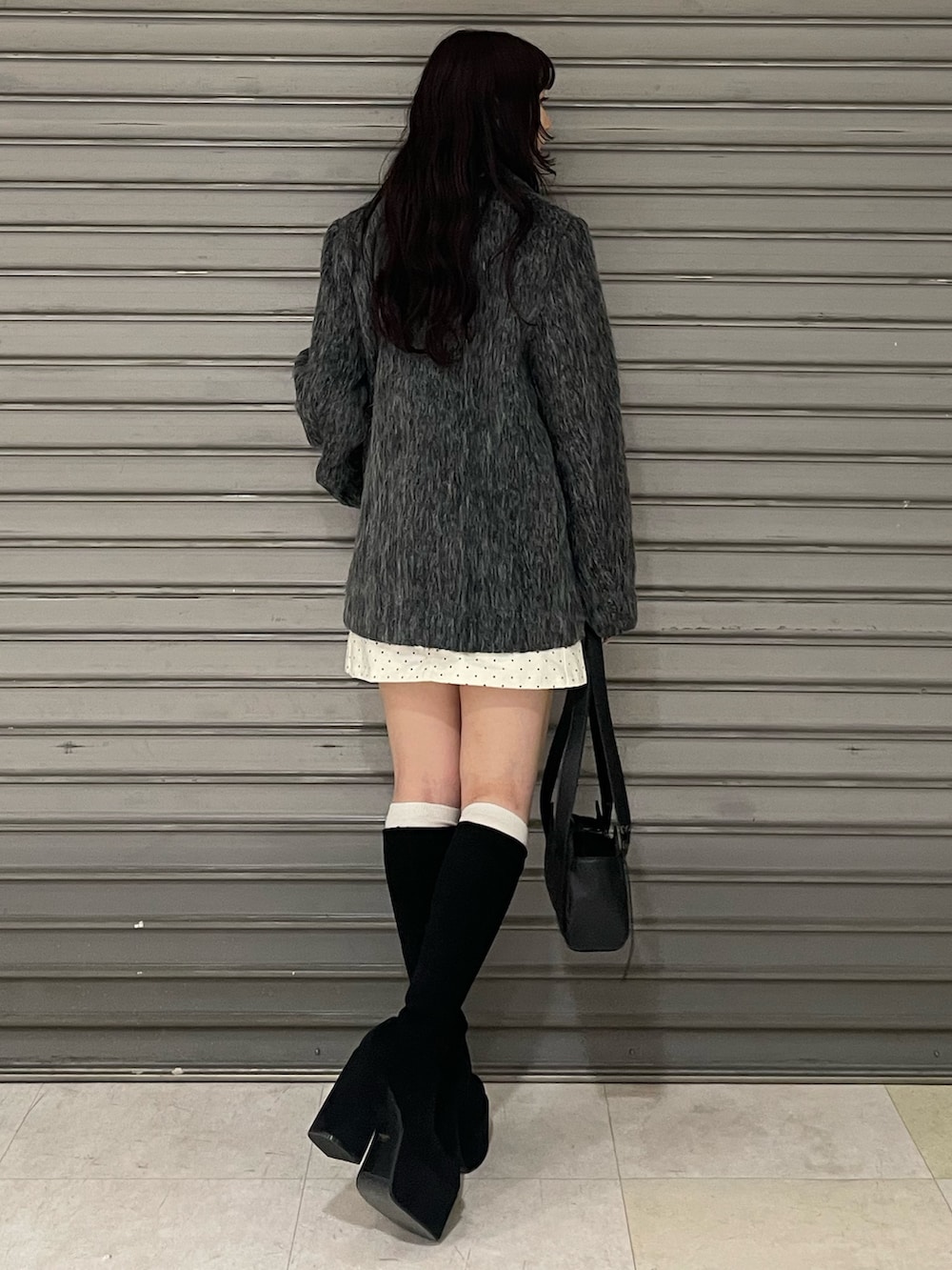 ブラック系のニット/セーター、グレー系のその他アウター、ホワイト系のスカートを着用したレディースの冬コーディネートの3枚目の写真