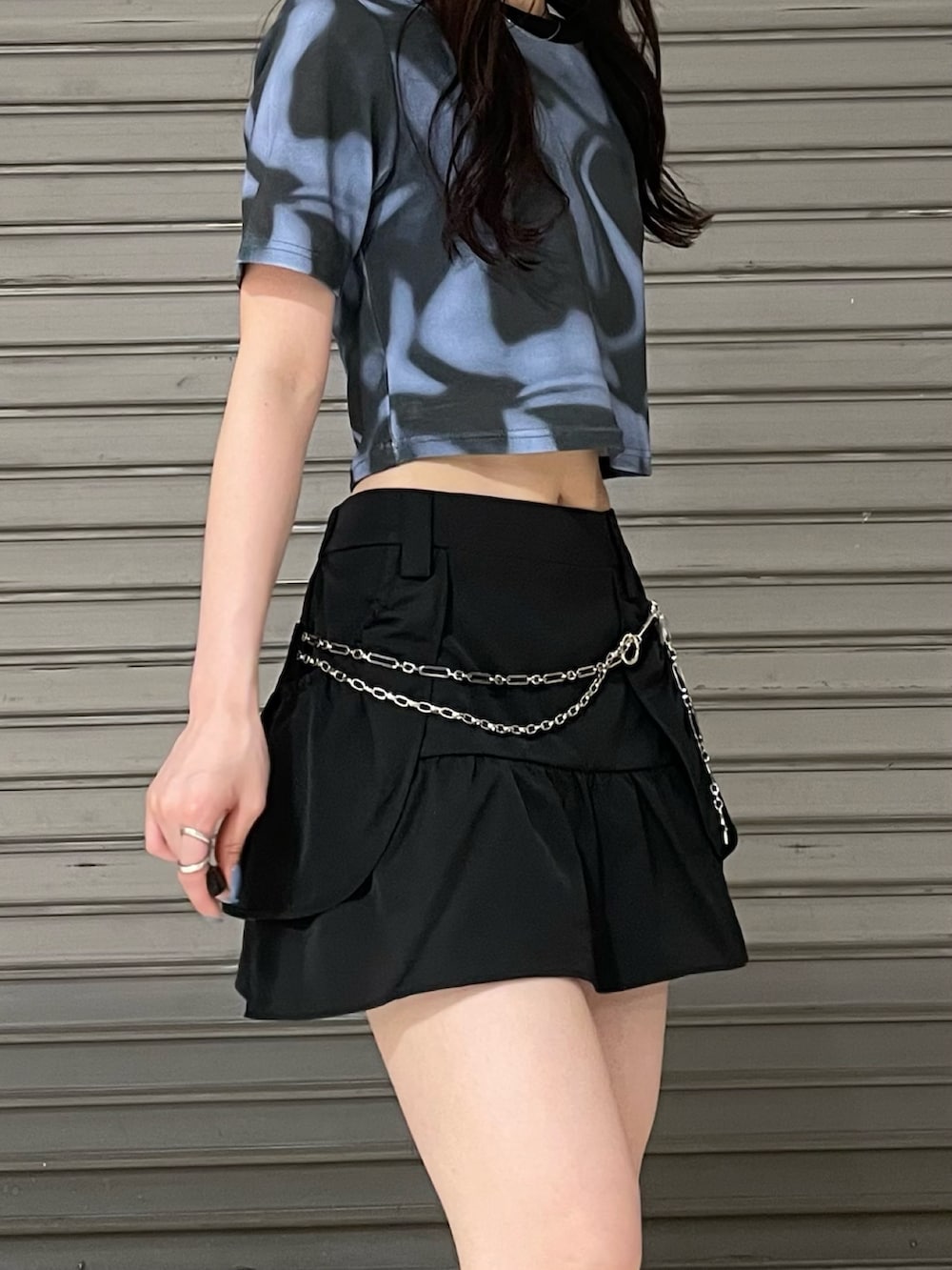 ブルー系のTシャツ/カットソー、ブラック系のスカート、ブラック系のサンダルを着用したレディースの夏コーディネートの4枚目の写真