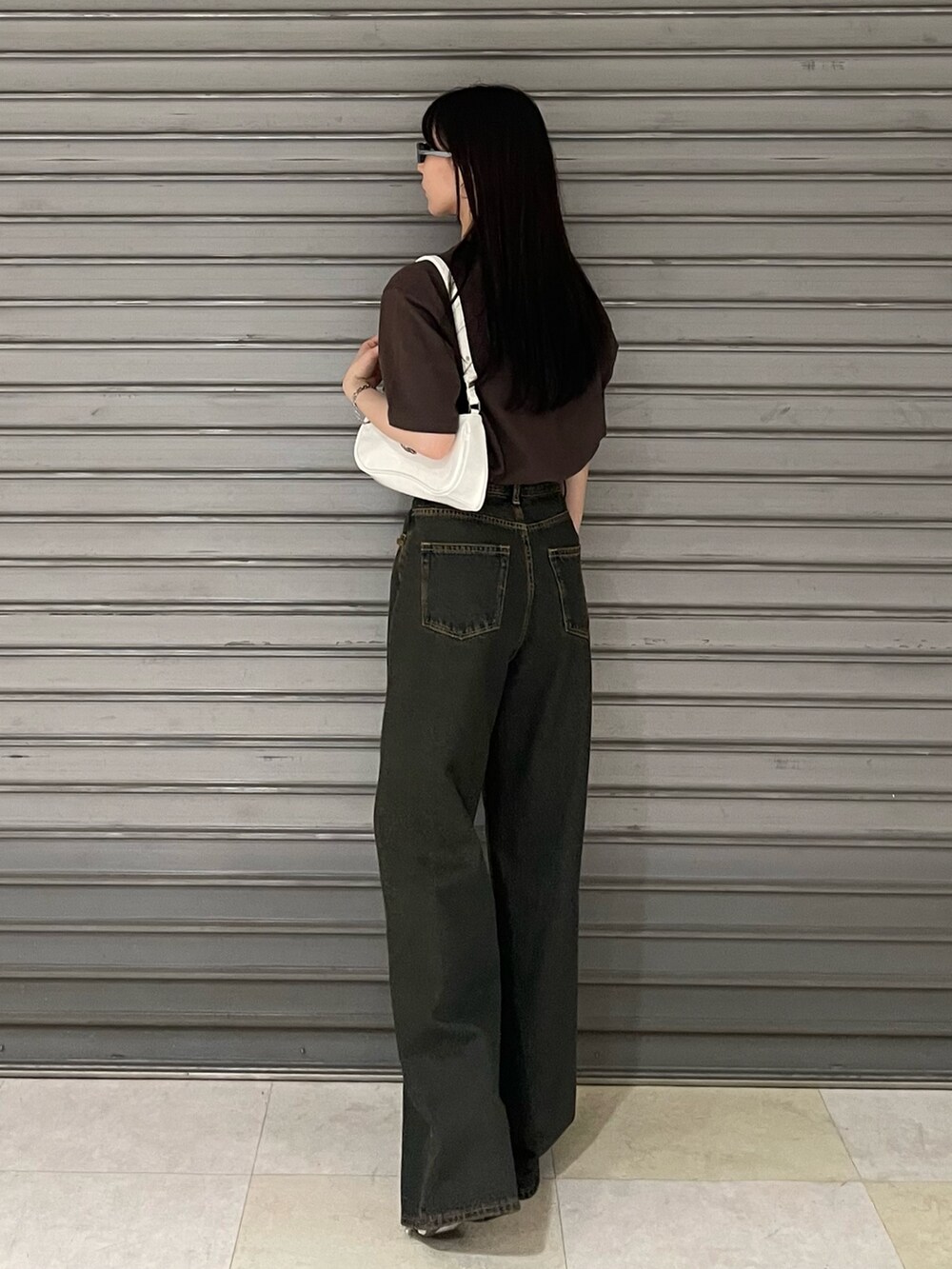 ブラウン系のTシャツ/カットソー、ブルー系のデニムパンツ、ホワイト系のパンプスを着用したレディースの春コーディネートの2枚目の写真