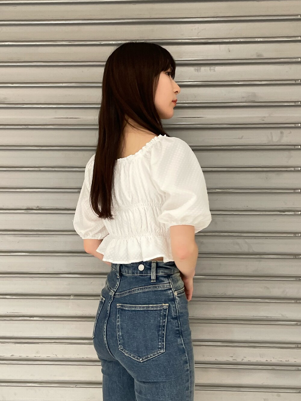 ホワイト系のTシャツ/カットソー、ブルー系のサロペット/オーバーオール、ブラック系のサンダルを着用したレディースの春コーディネートの6枚目の写真