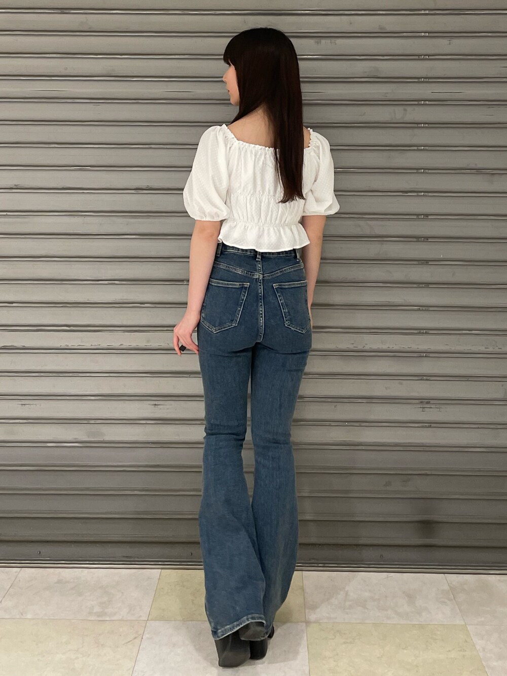 ホワイト系のTシャツ/カットソー、ブルー系のサロペット/オーバーオール、ブラック系のサンダルを着用したレディースの春コーディネートの5枚目の写真