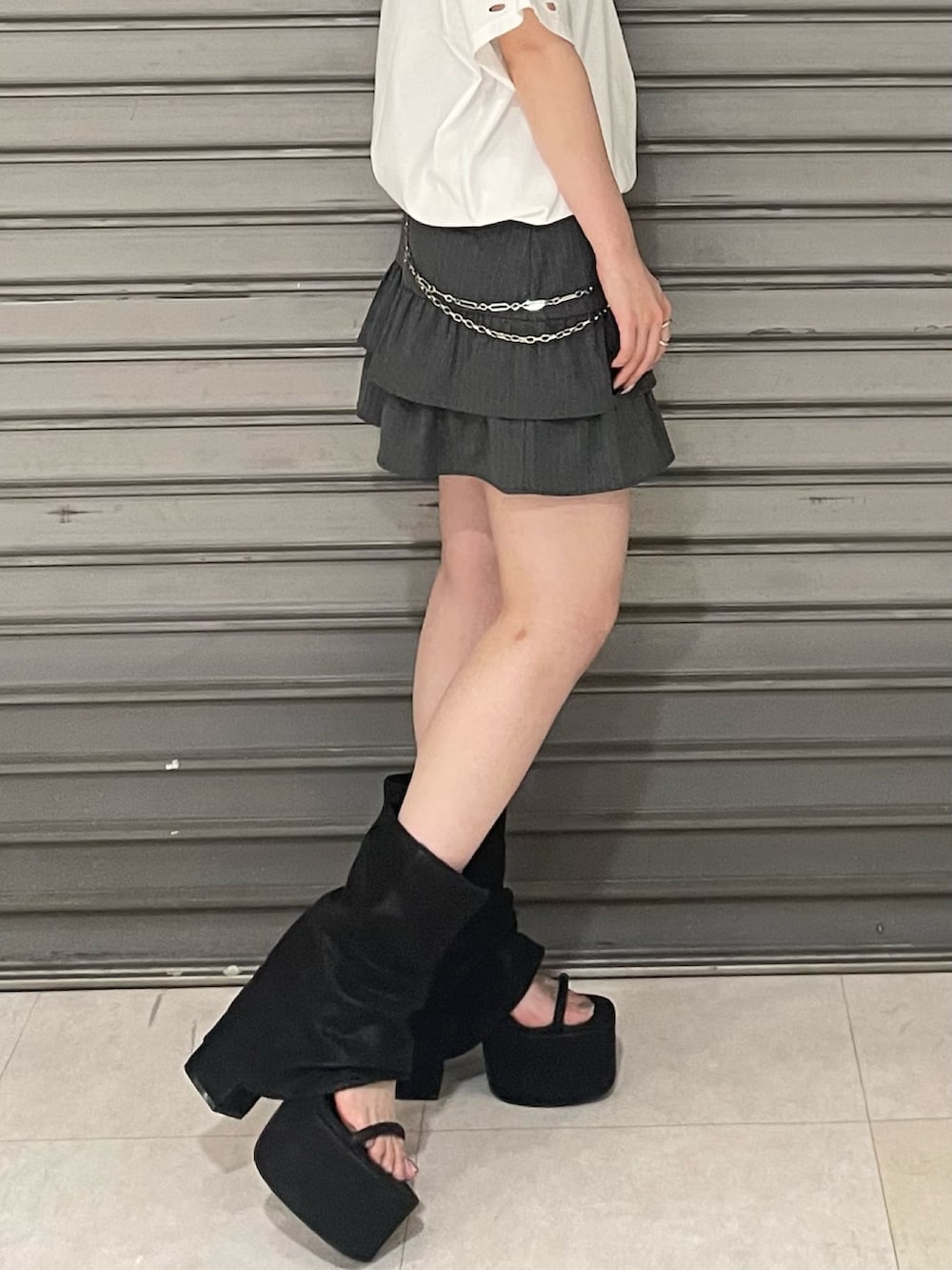 ホワイト系のTシャツ/カットソー、グレー系のスカート、ブラック系のサンダルを着用したレディースの夏コーディネートの6枚目の写真