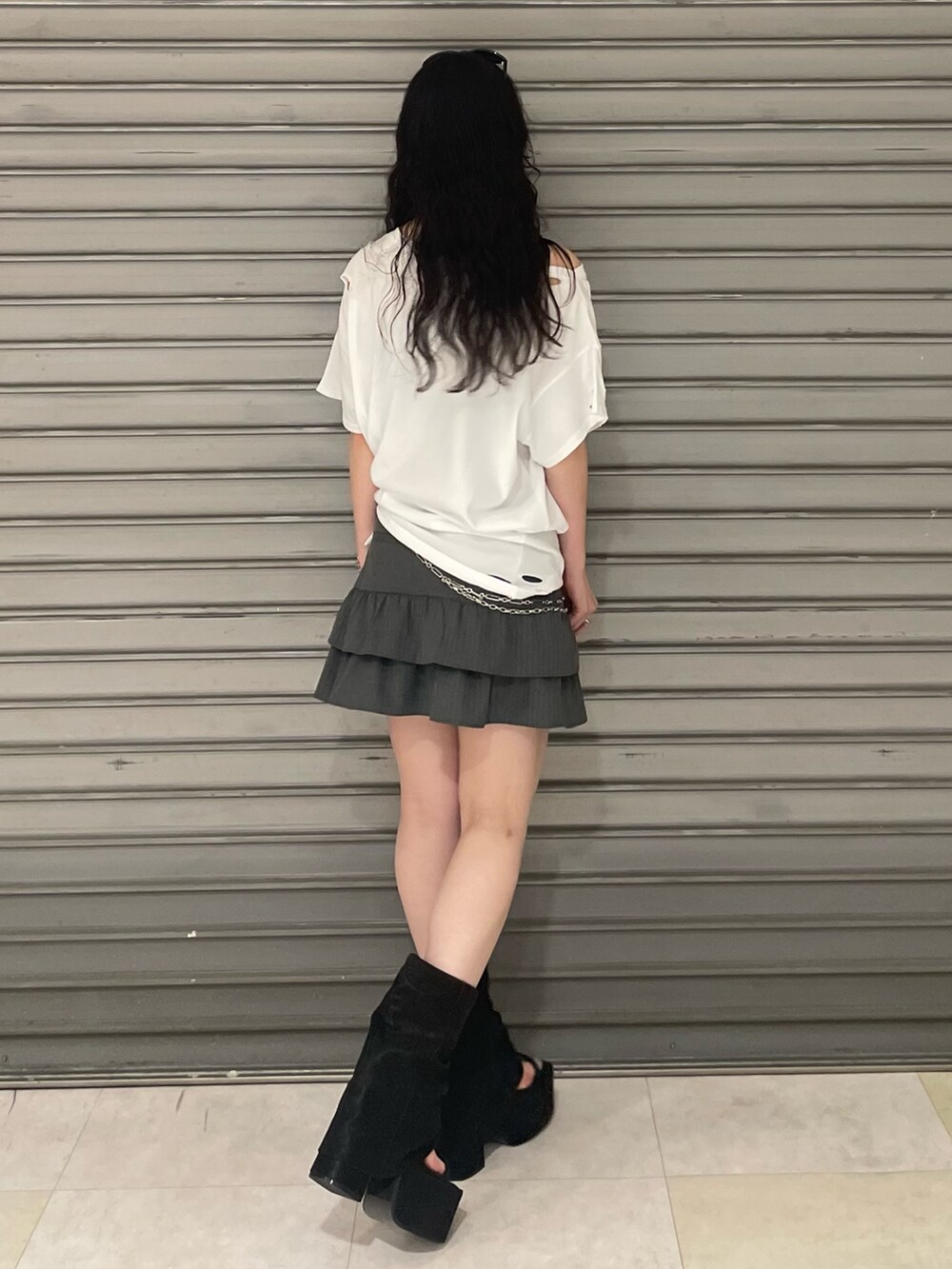 ホワイト系のTシャツ/カットソー、グレー系のスカート、ブラック系のサンダルを着用したレディースの夏コーディネートの3枚目の写真