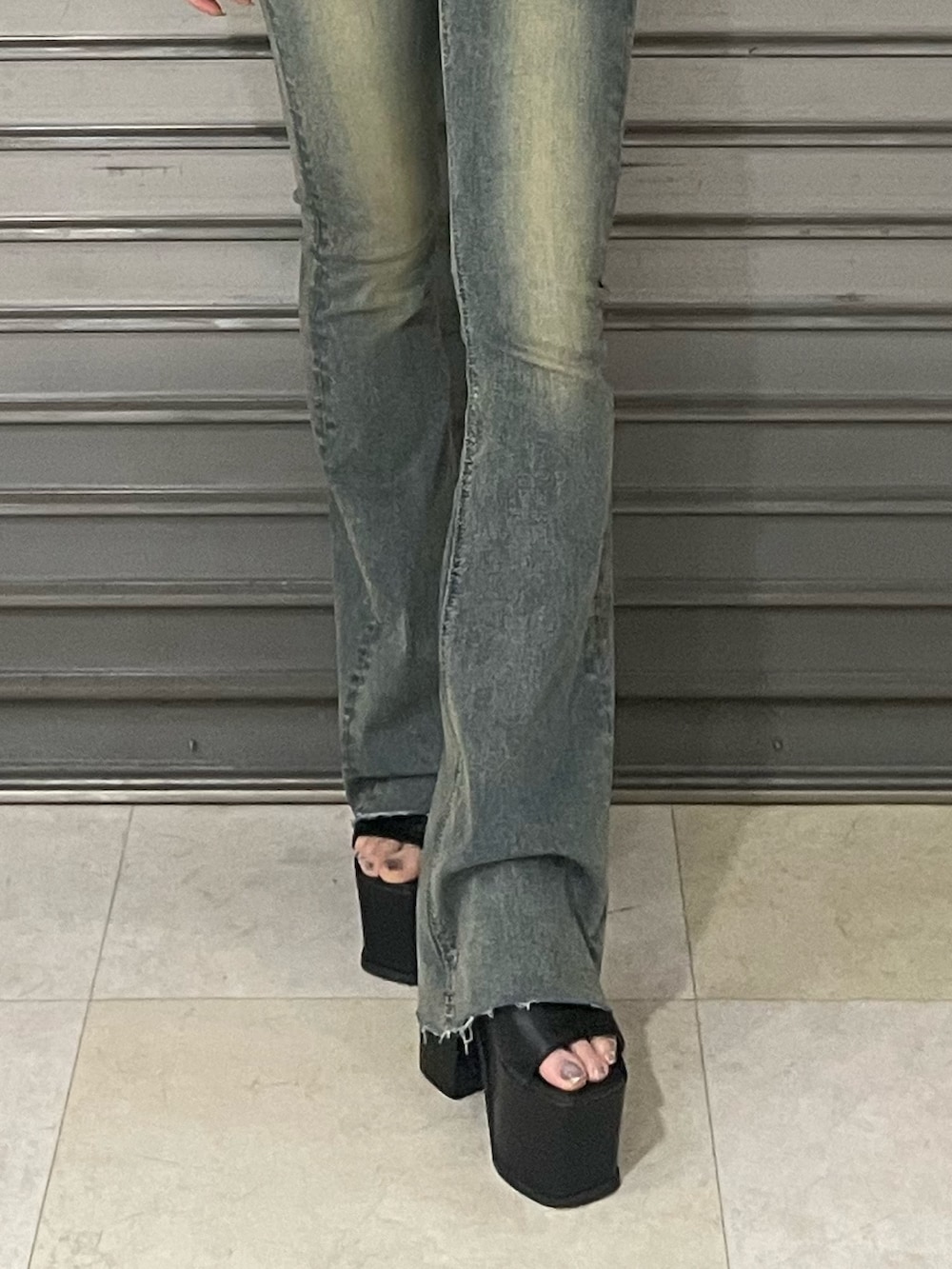 ブラック系のTシャツ/カットソー、ブルー系のデニムパンツ、ブラック系のサンダルを着用したレディースの春コーディネートの8枚目の写真