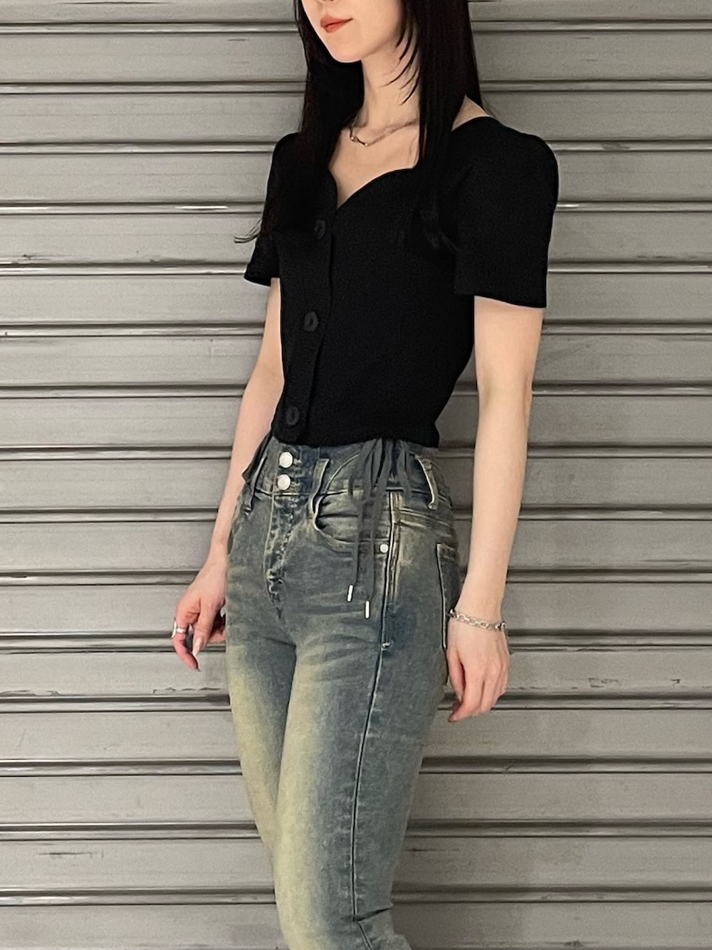 ブラック系のTシャツ/カットソー、ブルー系のデニムパンツ、ブラック系のサンダルを着用したレディースの春コーディネートの5枚目の写真