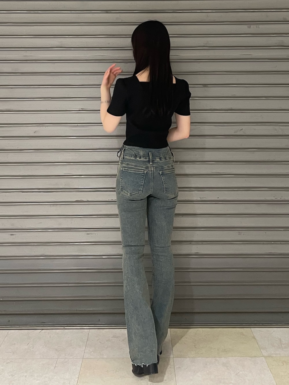 ブラック系のTシャツ/カットソー、ブルー系のデニムパンツ、ブラック系のサンダルを着用したレディースの春コーディネートの3枚目の写真