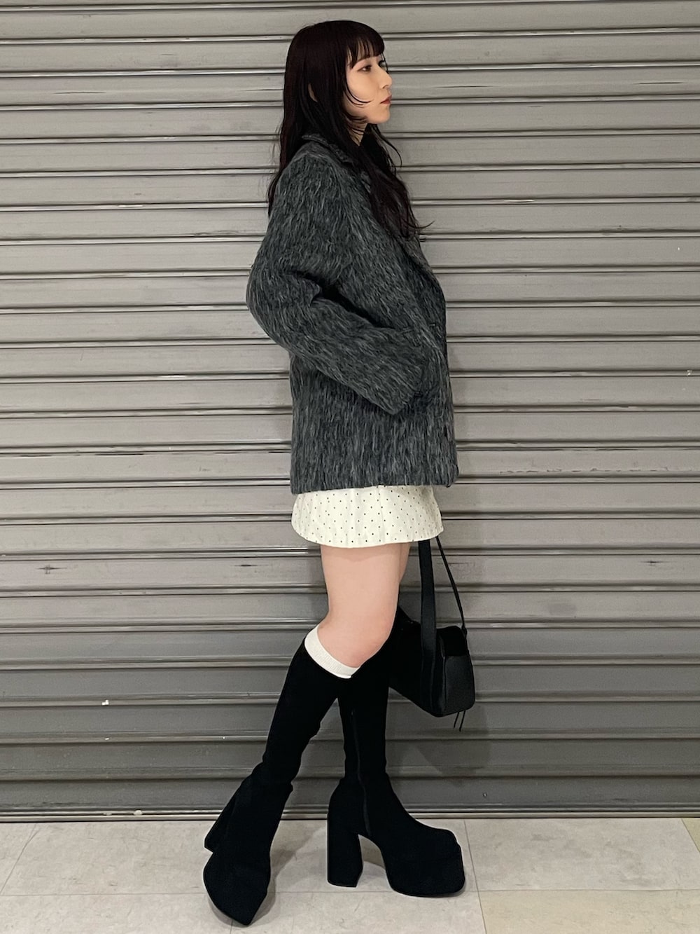 ブラック系のニット/セーター、グレー系のその他アウター、ホワイト系のスカートを着用したレディースの冬コーディネートの2枚目の写真