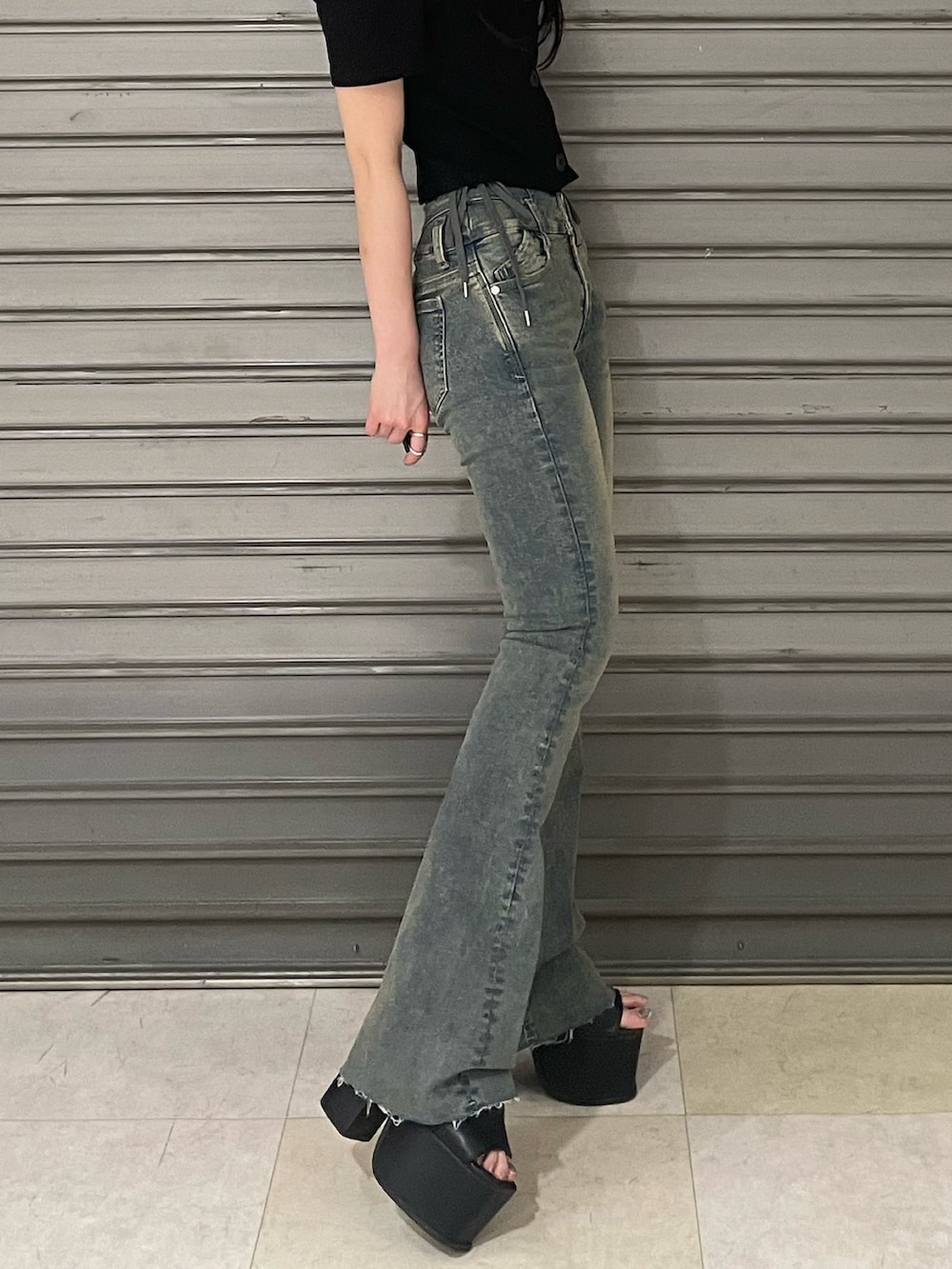 ブラック系のTシャツ/カットソー、ブルー系のデニムパンツ、ブラック系のサンダルを着用したレディースの春コーディネートの4枚目の写真