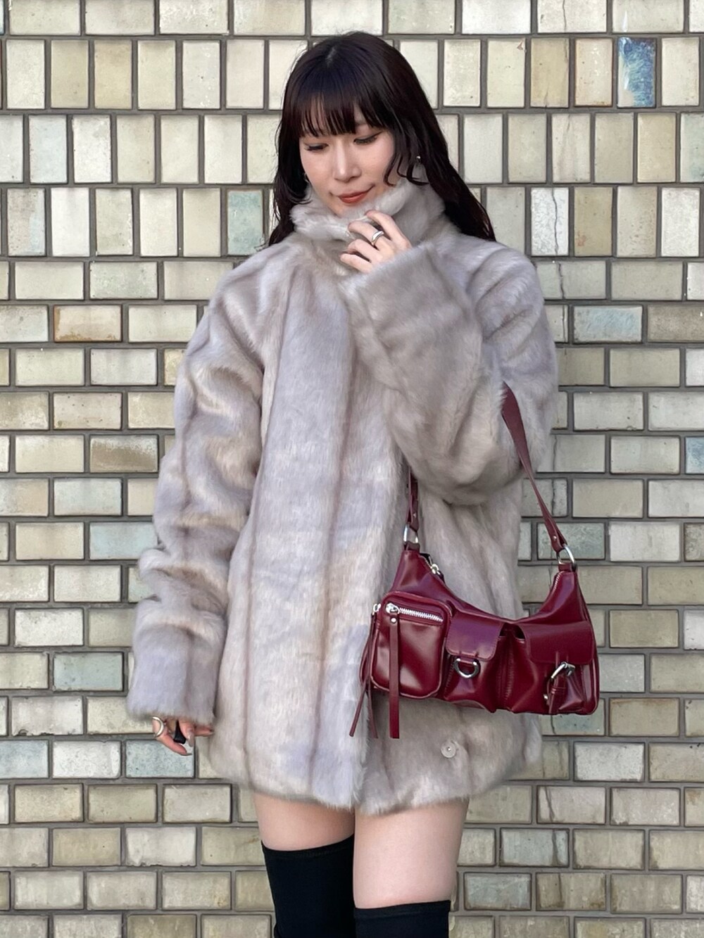 ブラック系のブーツ、レッド系のハンドバッグ、ブラック系のニット/セーターを着用したレディースの秋コーディネートの4枚目の写真