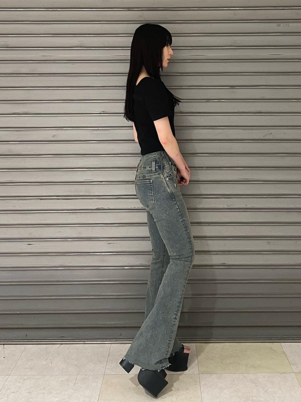 ブラック系のTシャツ/カットソー、ブルー系のデニムパンツ、ブラック系のサンダルを着用したレディースの春コーディネートの2枚目の写真