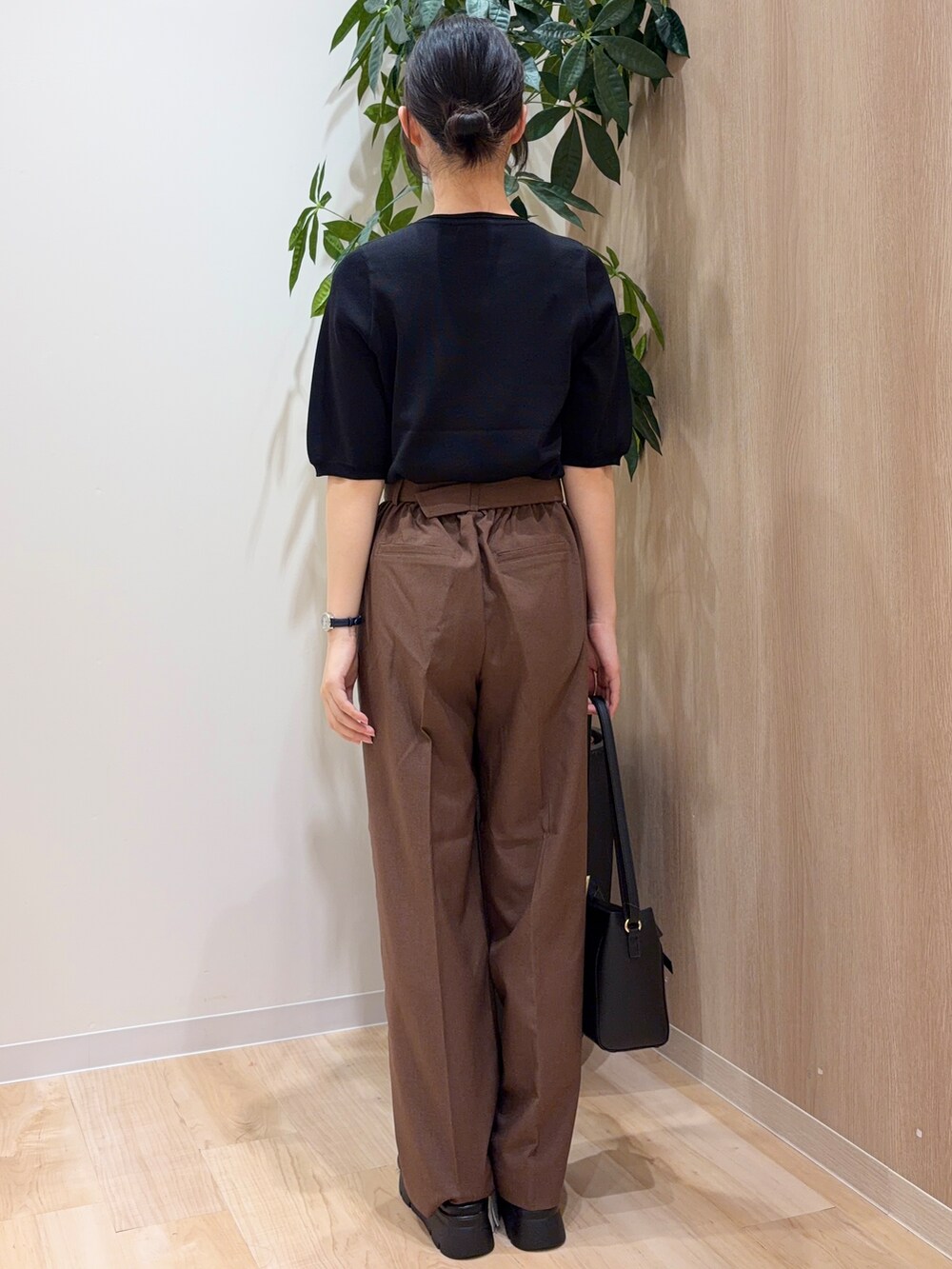 ブラック系のニット/セーター、ブラウン系のその他パンツ、ブラック系のショルダーバッグを着用したレディースの夏コーディネートの3枚目の写真