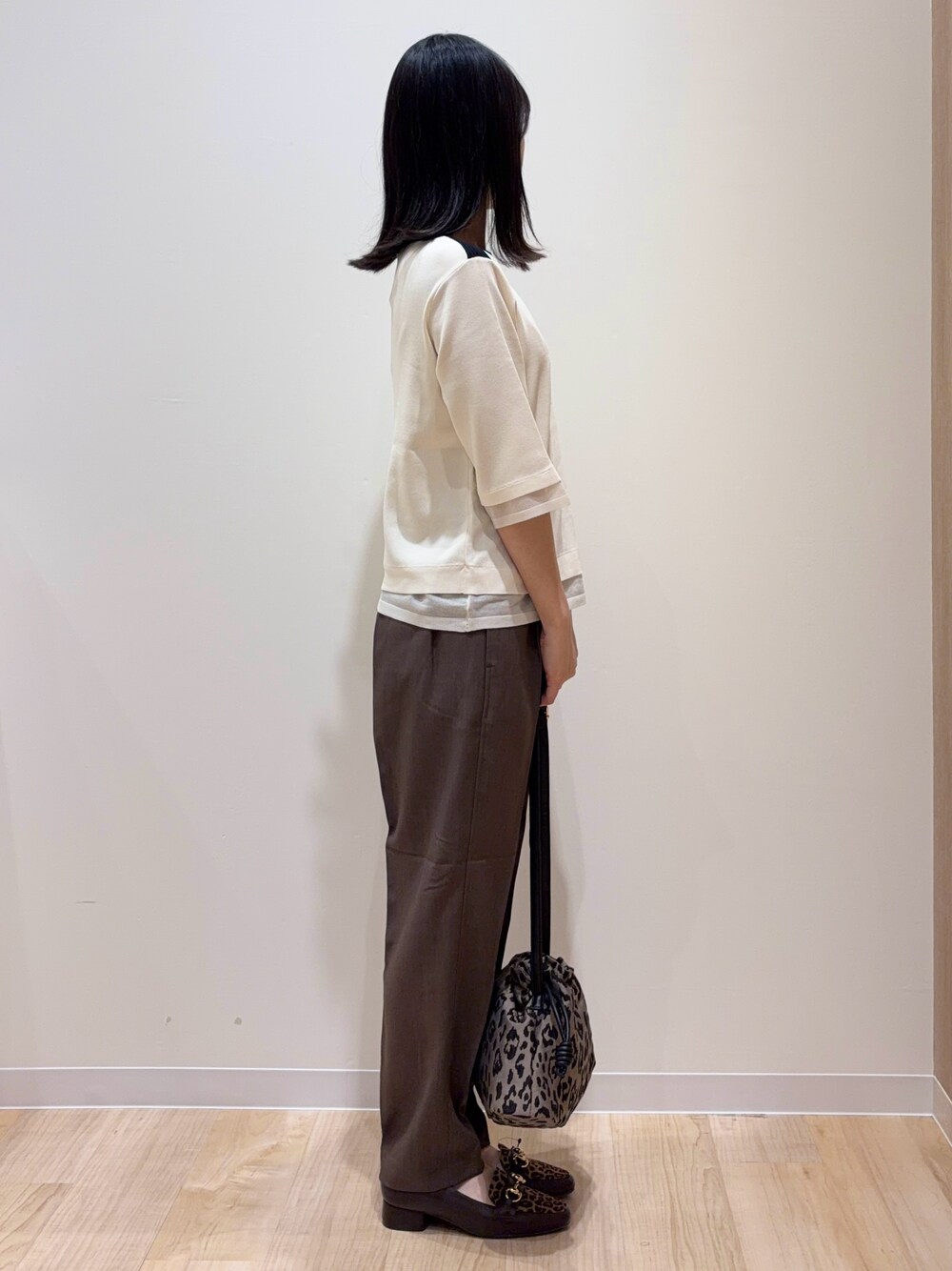ホワイト系のニット/セーター、ブラウン系のその他パンツ、ブラウン系のショルダーバッグを着用したレディースの秋コーディネートの2枚目の写真