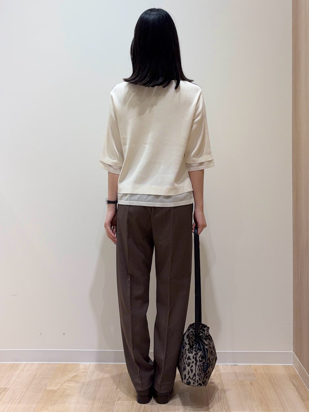 ホワイト系のニット/セーター、ブラウン系のその他パンツ、ブラウン系のショルダーバッグを着用したレディースの秋コーディネートの3枚目の写真