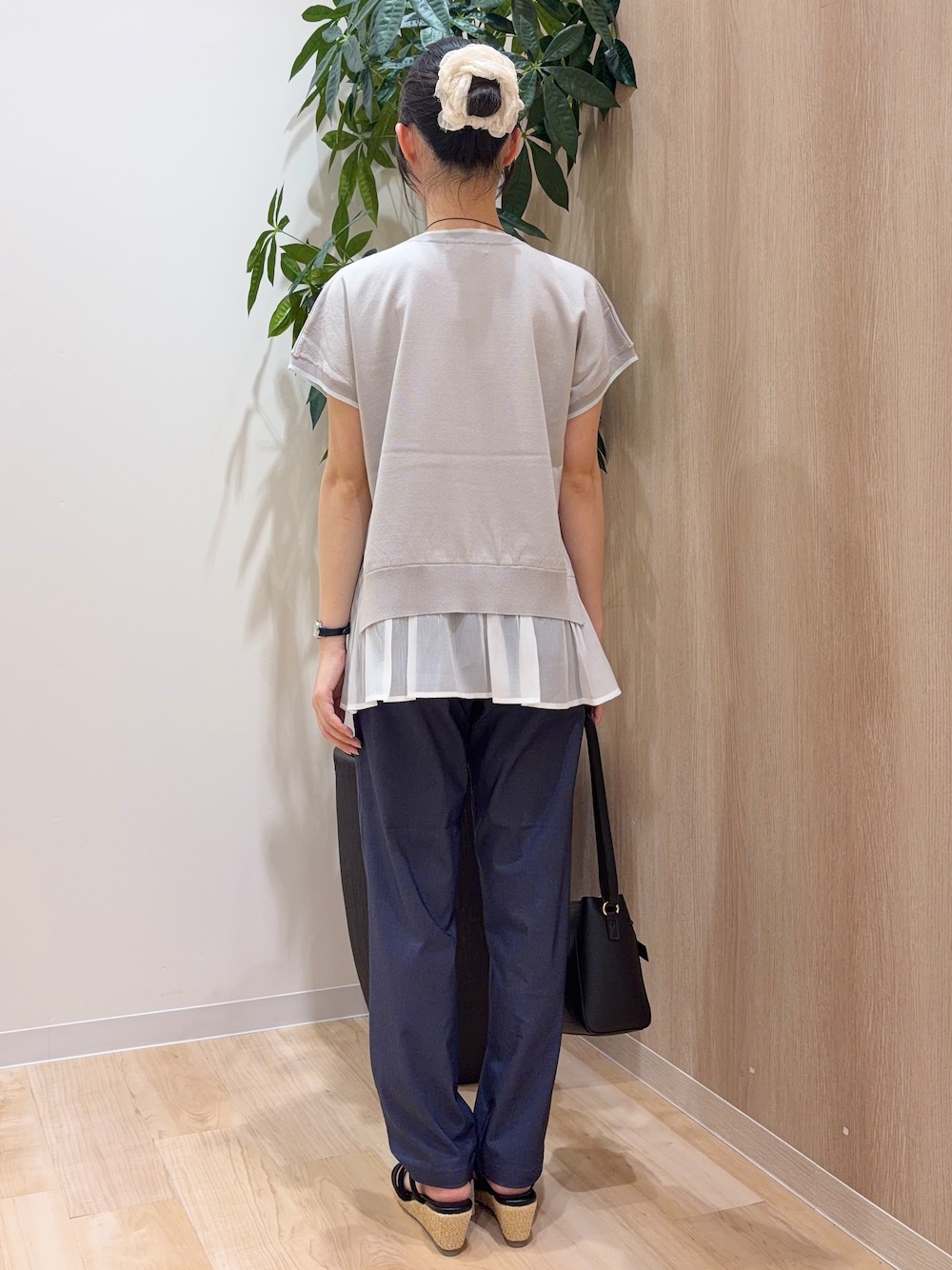 グレー系のニット/セーター、ブルー系のその他パンツ、ブラック系のショルダーバッグを着用したレディースの夏コーディネートの3枚目の写真