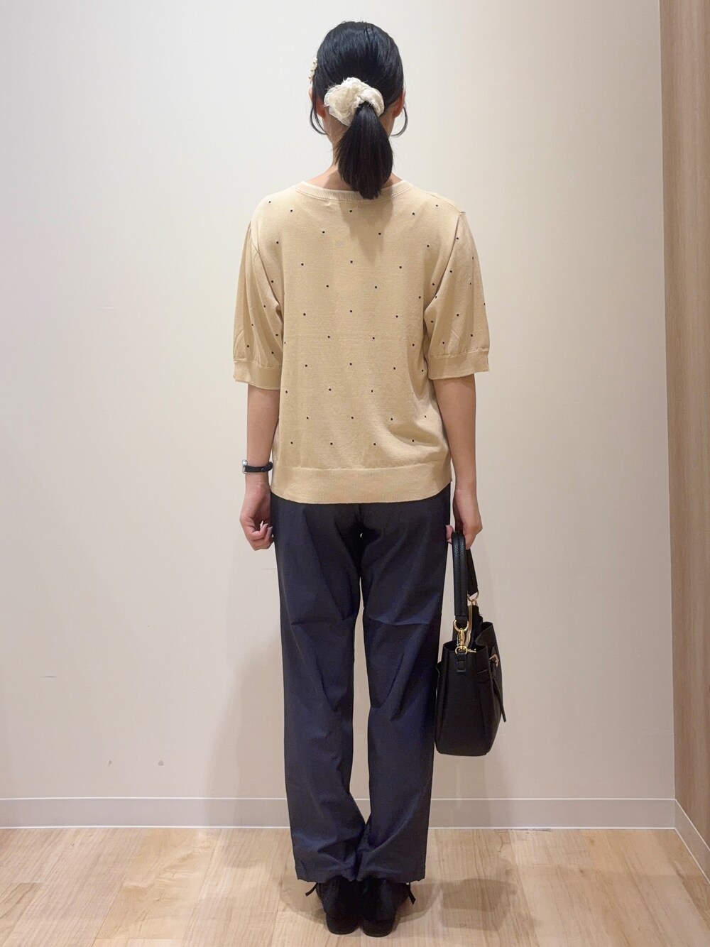 ベージュ系のニット/セーター、ブルー系のその他パンツ、ブラック系のショルダーバッグを着用したレディースの秋コーディネートの3枚目の写真