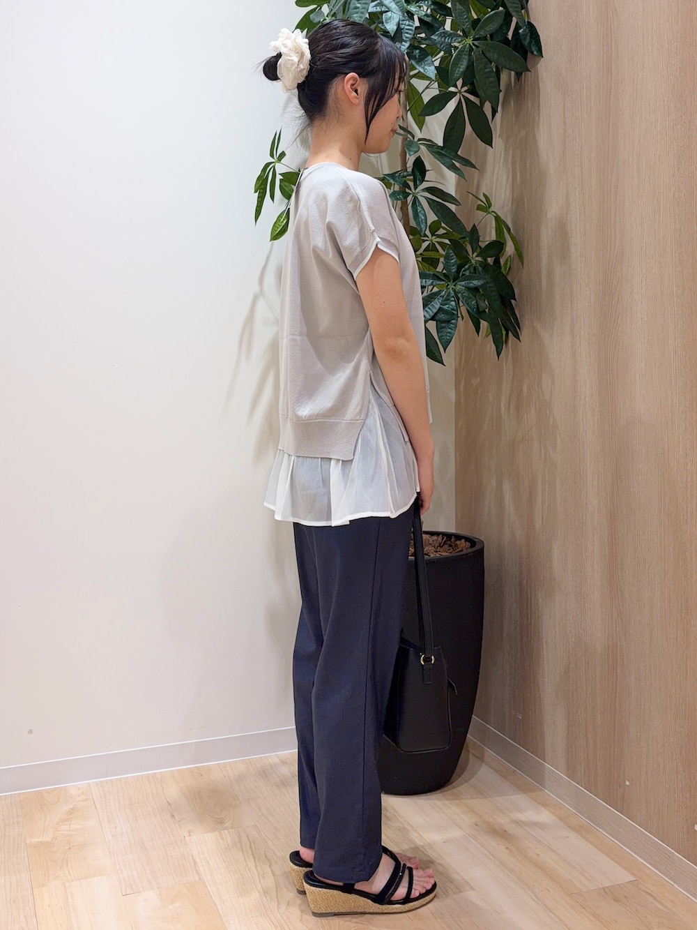 グレー系のニット/セーター、ブルー系のその他パンツ、ブラック系のショルダーバッグを着用したレディースの夏コーディネートの2枚目の写真