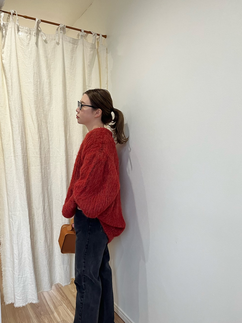 レッド系のカーディガン/ボレロ、ホワイト系のTシャツ/カットソー、ブラック系のデニムパンツを着用したレディースの冬コーディネートの2枚目の写真