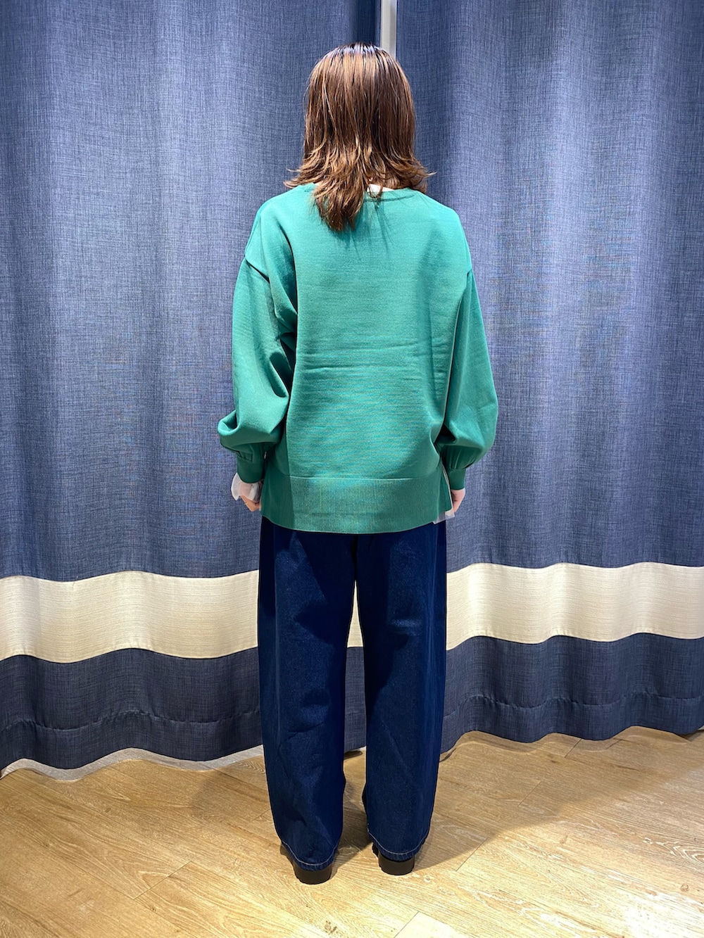 グリーン系のニット/セーター、ホワイト系のTシャツ/カットソー、ブルー系のその他パンツを着用したレディースの秋コーディネートの2枚目の写真