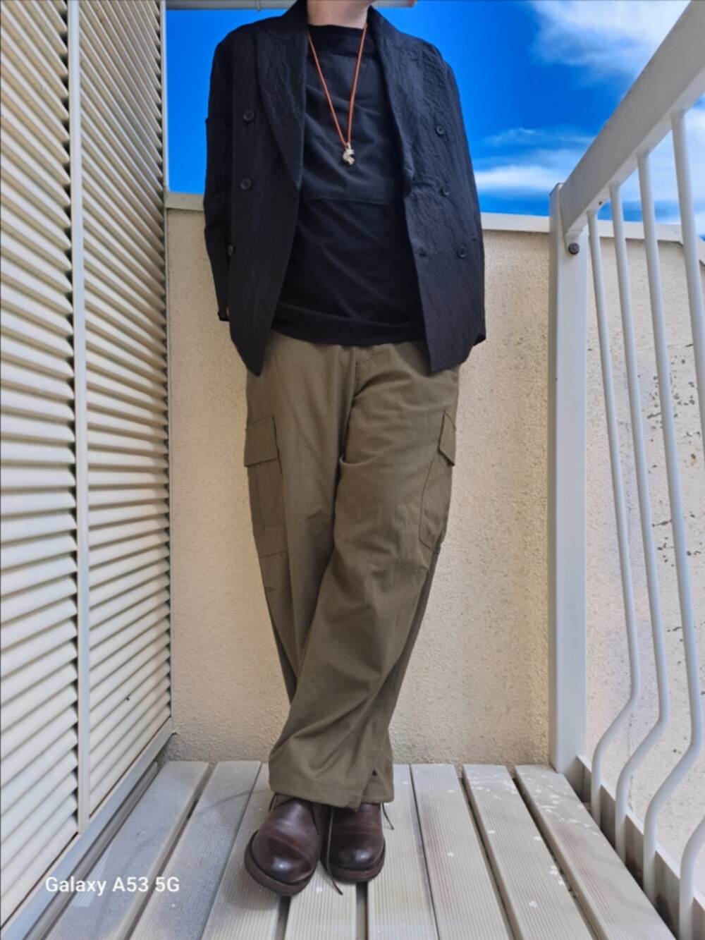 グリーン系のカーゴパンツ、ブラック系のTシャツ/カットソーを着用したメンズの夏コーディネートの2枚目の写真