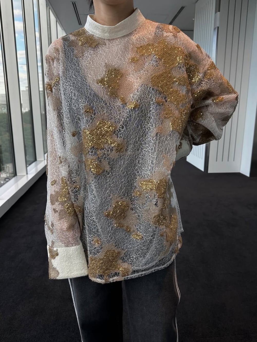 ブラック系のデニムパンツ、ホワイト系のTシャツ/カットソー、シルバー系のパンプスを着用したレディースの冬コーディネートの2枚目の写真