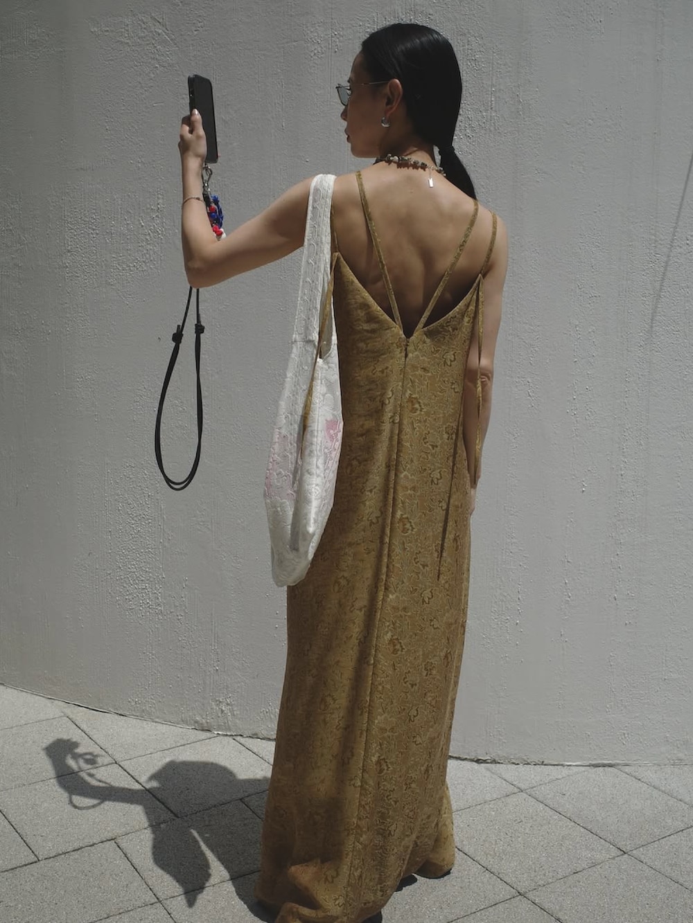 イエロー系のワンピースを着用したレディースの夏コーディネートの2枚目の写真