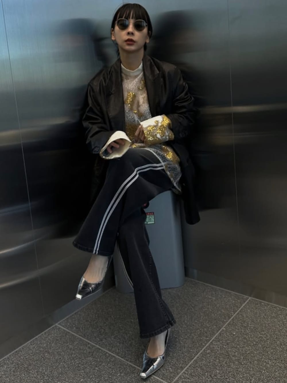 ブラック系のデニムパンツ、ホワイト系のTシャツ/カットソー、シルバー系のパンプスを着用したレディースの冬コーディネートの5枚目の写真