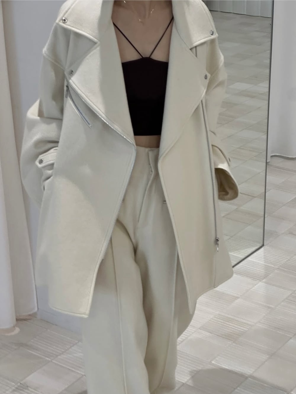 ホワイト系のピーコート、ホワイト系のスラックスを着用したレディースの秋コーディネートの2枚目の写真