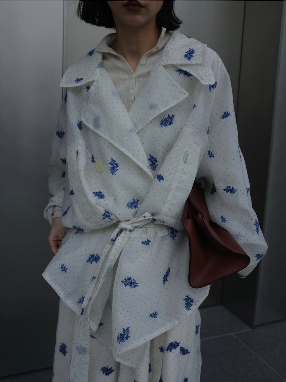 ホワイト系のトレンチコートを着用したレディースの春コーディネートの2枚目の写真