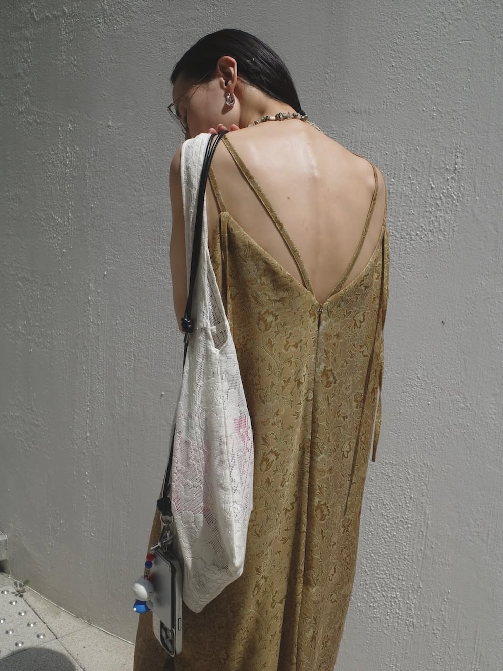 イエロー系のワンピースを着用したレディースの夏コーディネートの3枚目の写真