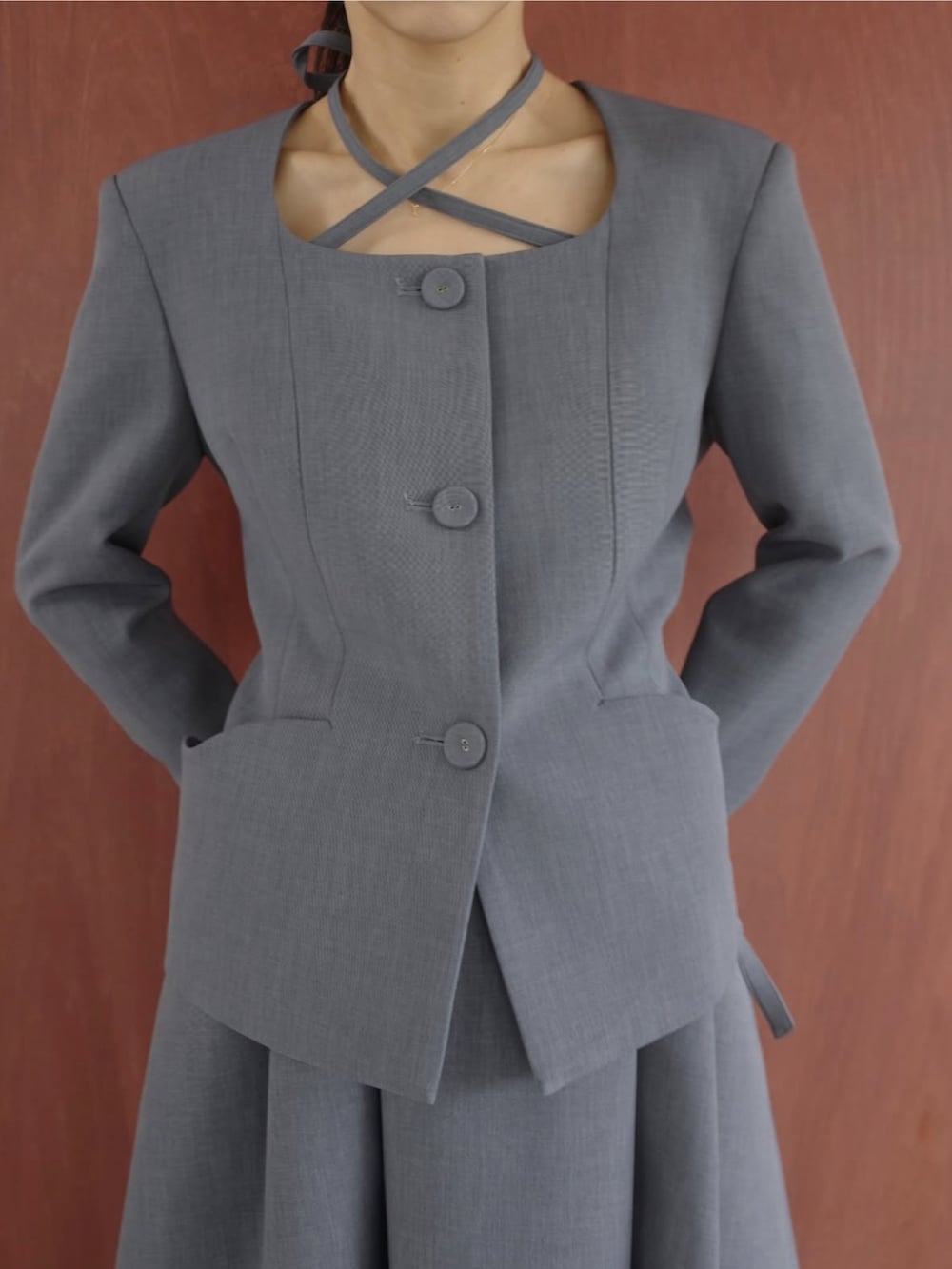 グレー系のスーツスカート、グレー系のノーカラージャケットを着用したレディースの冬コーディネートの2枚目の写真