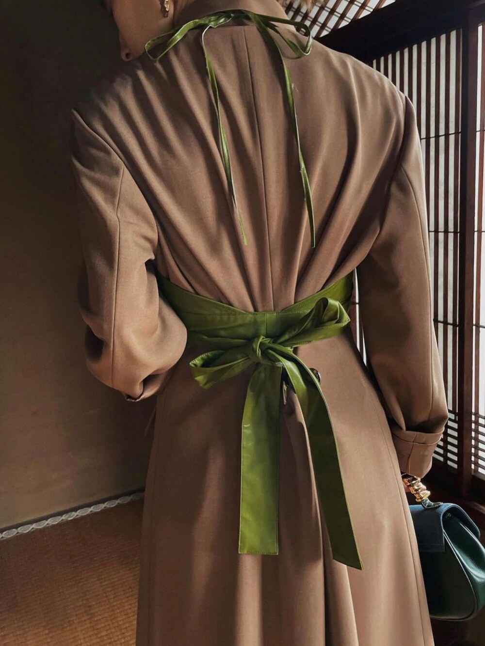 ブラウン系のワンピース、ブラック系のスカート、ゴールド系のピアス（両耳用）を着用したレディースの冬コーディネートの5枚目の写真