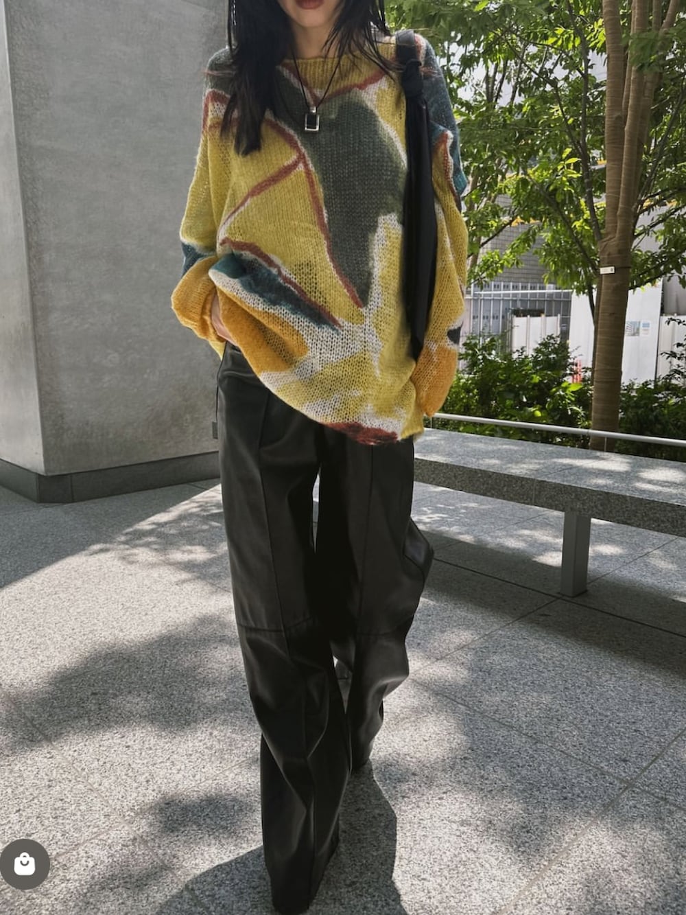 イエロー系のニット/セーター、ブラック系のパンツを着用したレディースの秋コーディネートの2枚目の写真