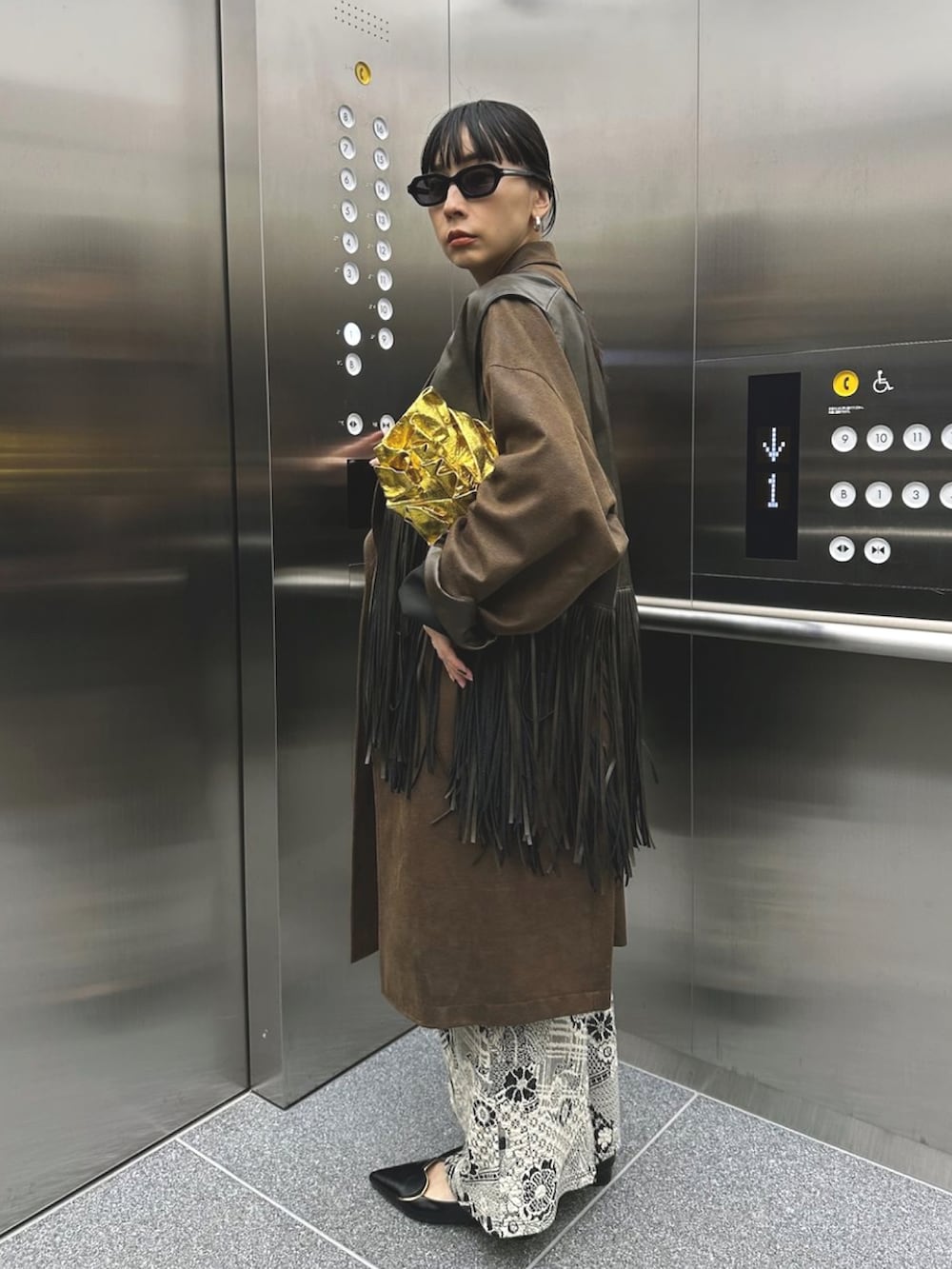 ブラック系のパンプス、ブラウン系のテーラードジャケットを着用したレディースの秋コーディネートの3枚目の写真