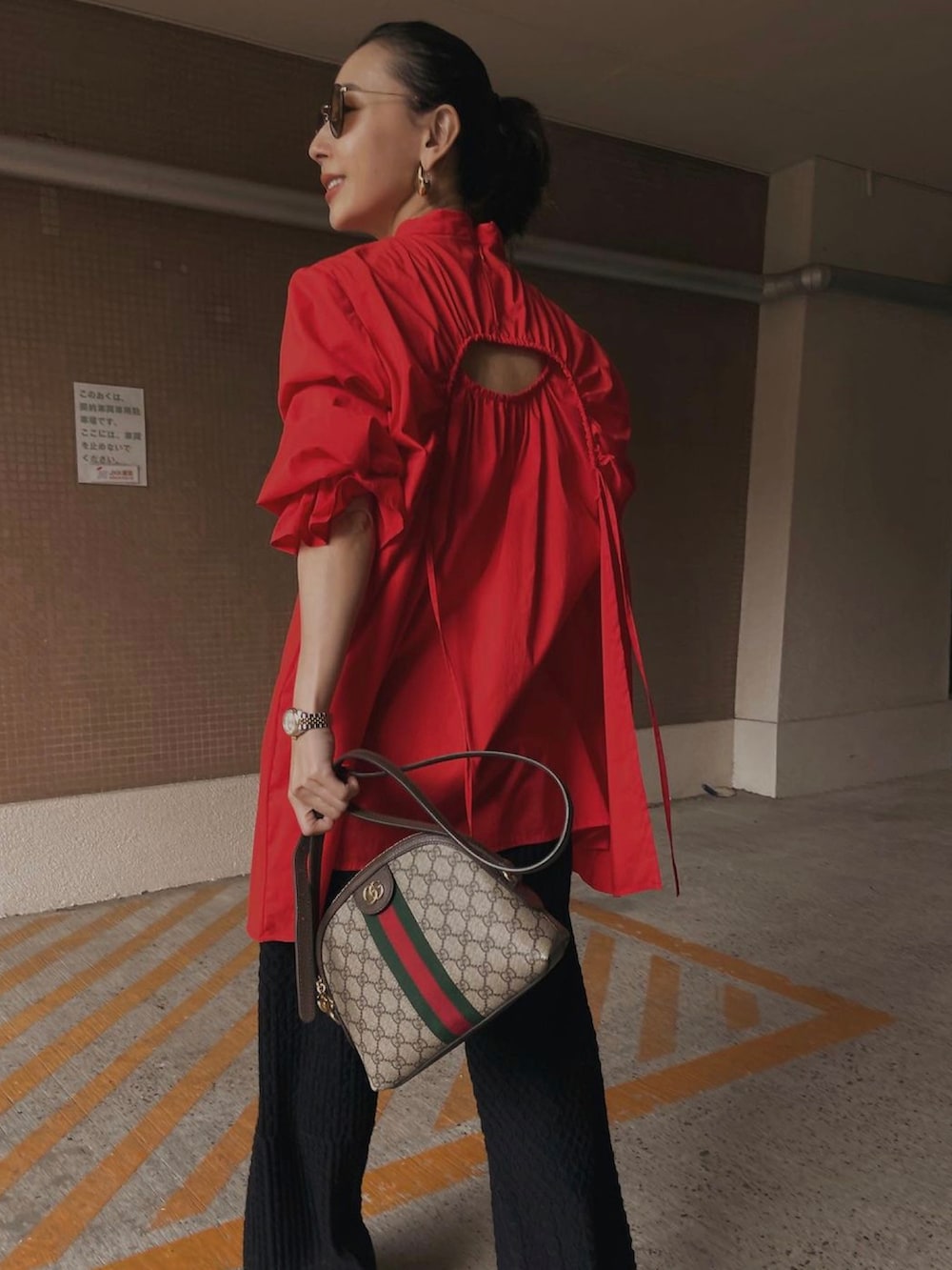 レッド系のシャツ/ブラウス、ブラック系のその他パンツ、ブラウン系のバッグを着用したレディースの冬コーディネートの2枚目の写真