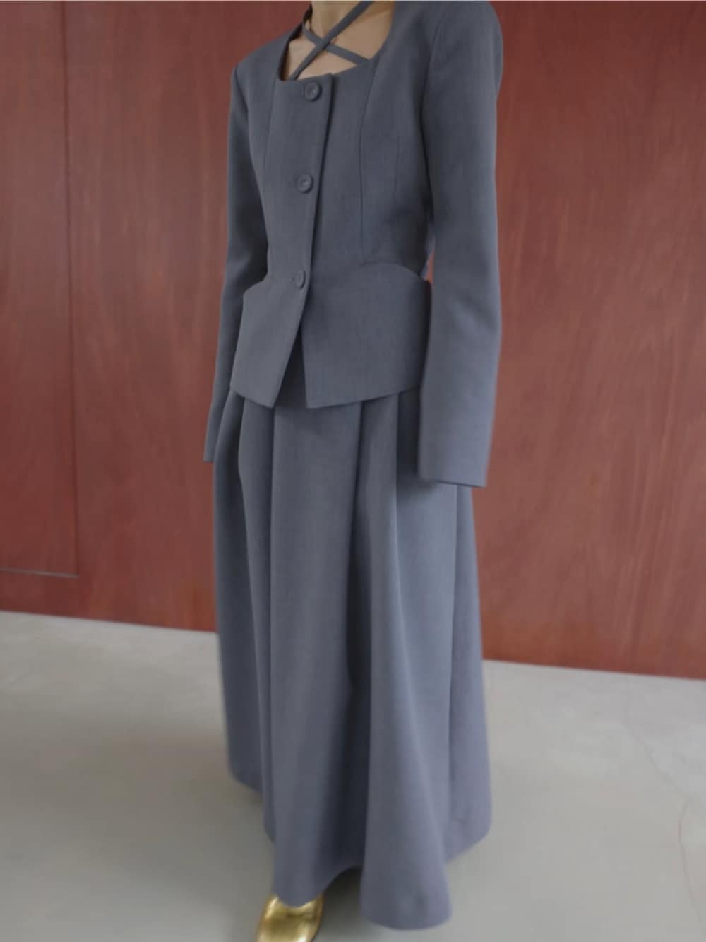 グレー系のスーツスカート、グレー系のノーカラージャケットを着用したレディースの冬コーディネートの4枚目の写真