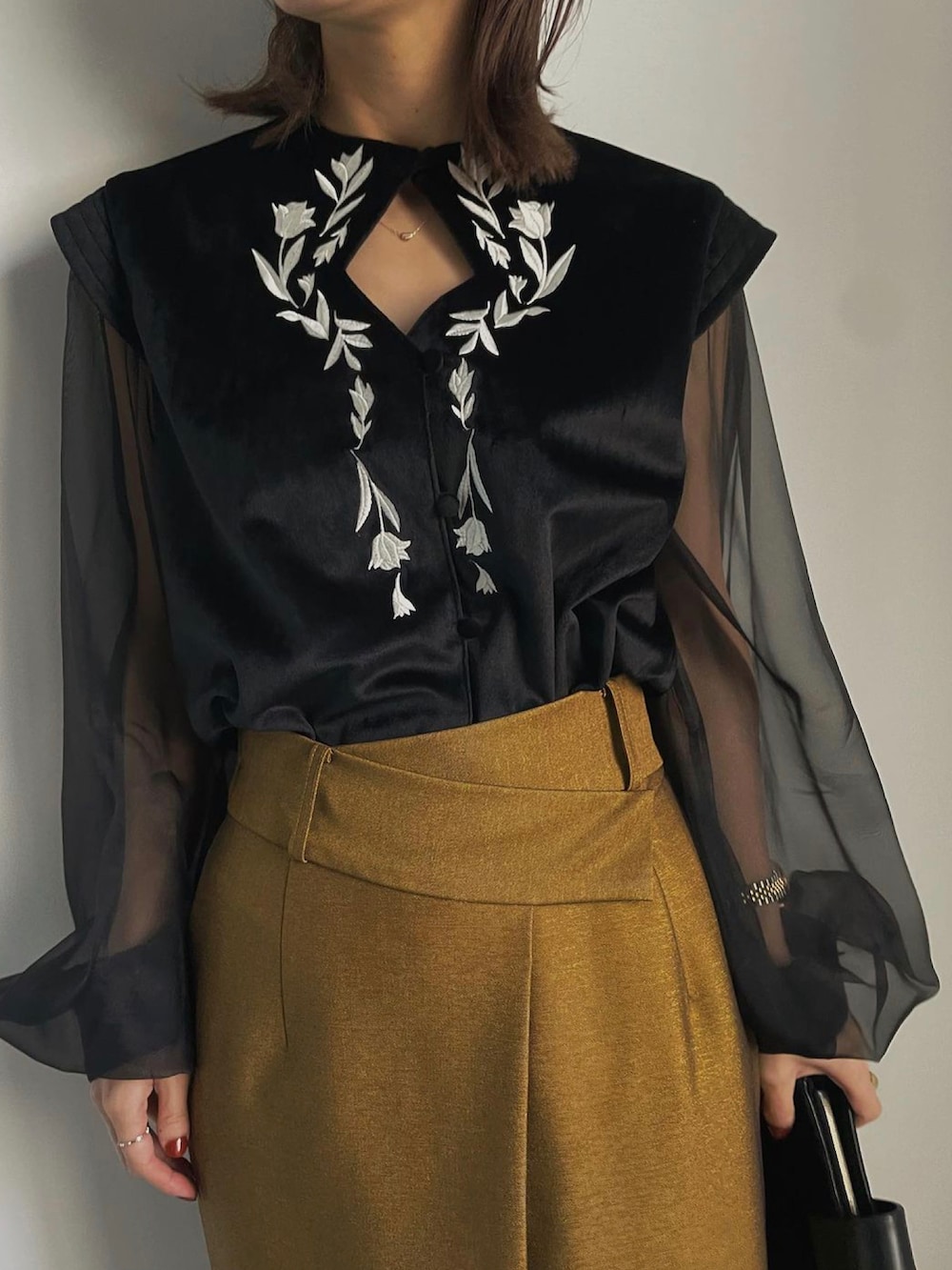 イエロー系のスカート、ブラック系のブーツ、ブラック系のシャツ/ブラウスを着用したレディースの冬コーディネートの4枚目の写真