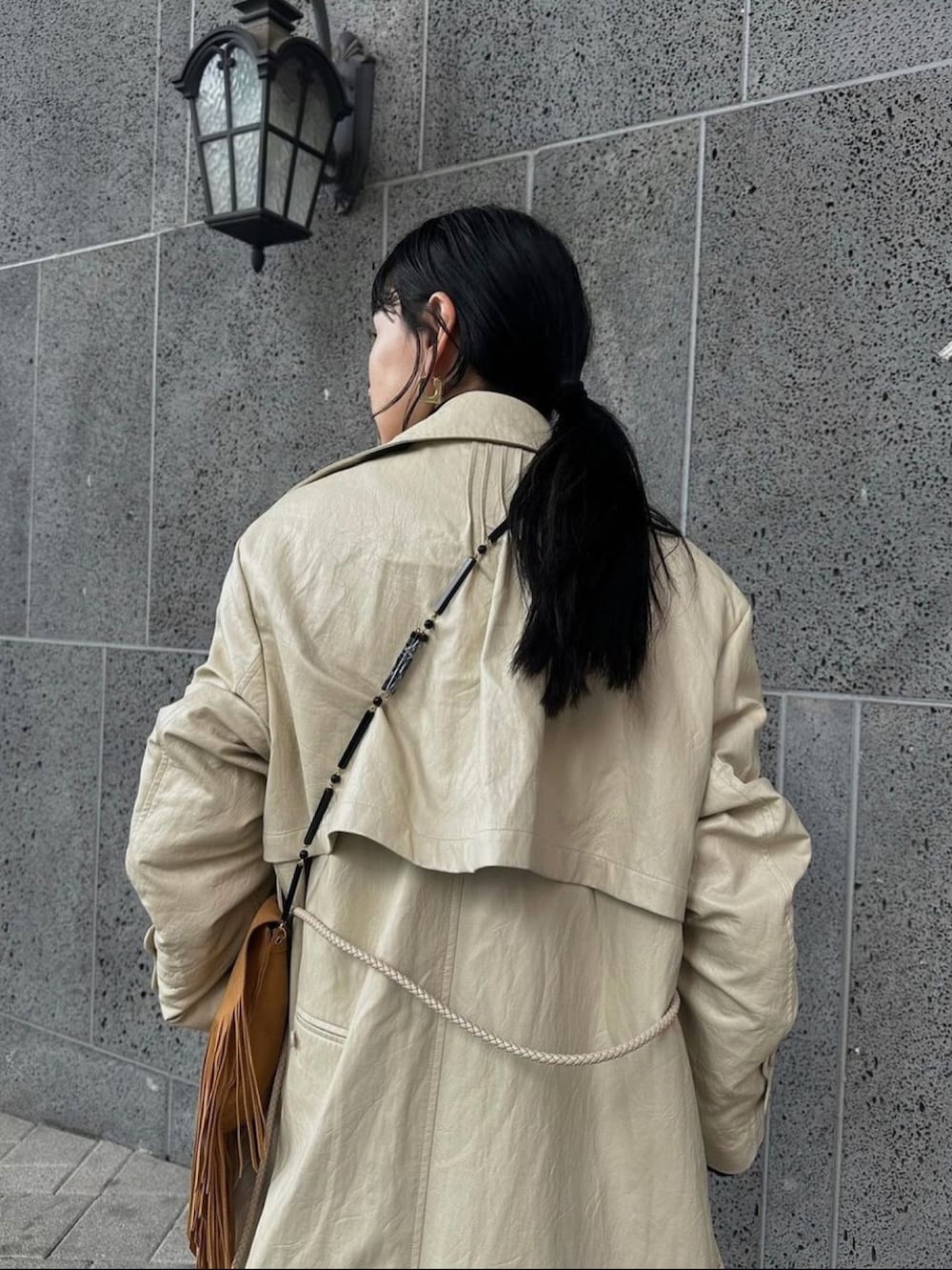 ホワイト系のトレンチコート、ベージュ系のベストを着用したレディースの秋コーディネートの4枚目の写真