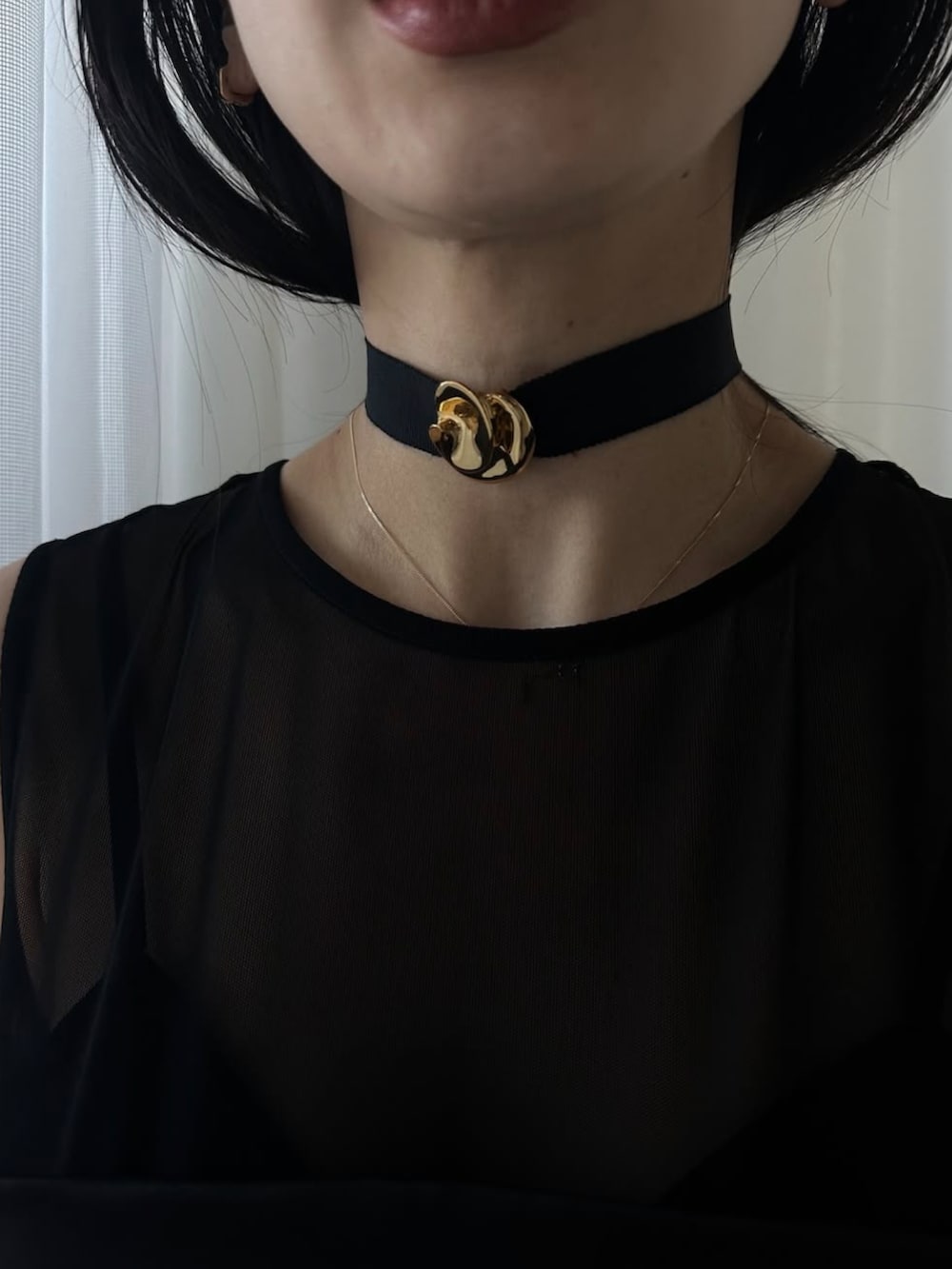 ブラック系のドレス、ゴールド系のチョーカーを着用したレディースの冬コーディネートの4枚目の写真