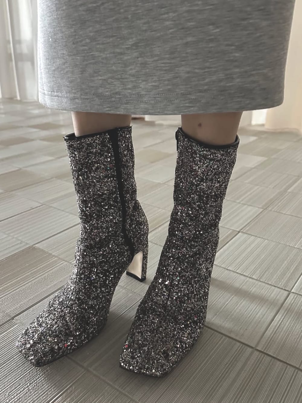 グレー系のワンピース、シルバー系のブーツを着用したレディースの冬コーディネートの4枚目の写真