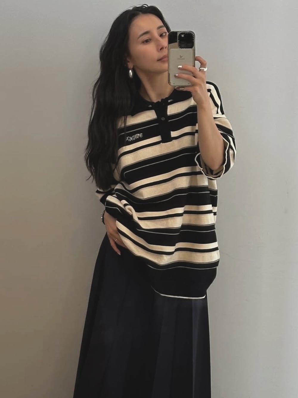 オレンジ系のポロシャツを着用したレディースの秋コーディネートの3枚目の写真