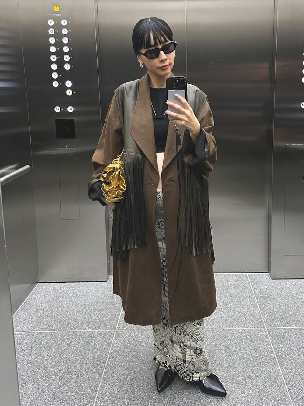 ブラック系のパンプス、ブラウン系のテーラードジャケットを着用したレディースの秋コーディネートの2枚目の写真