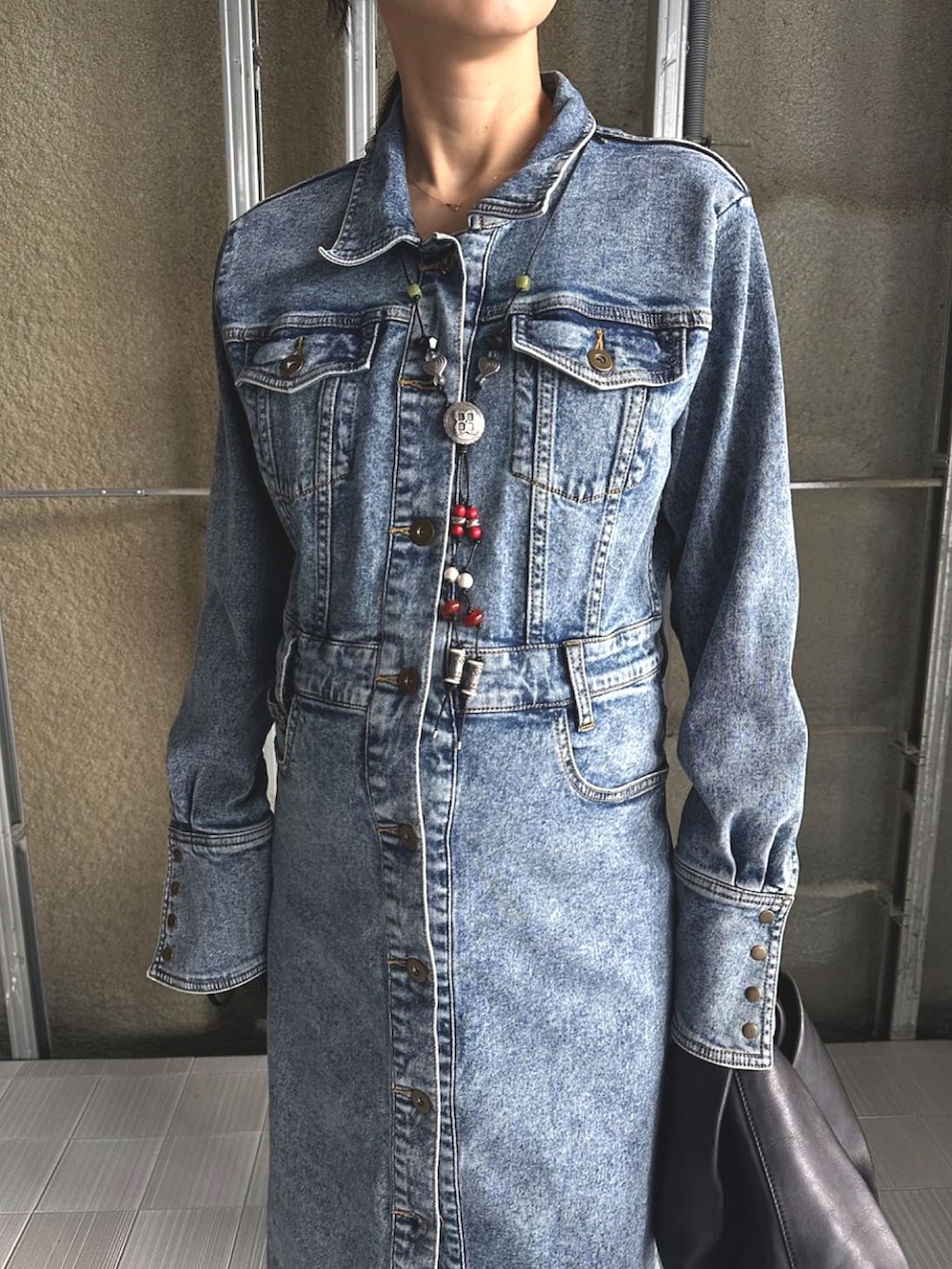 ブラック系のスニーカー、ブラック系のワンピース、シルバー系のネックレスを着用したレディースの秋コーディネートの2枚目の写真