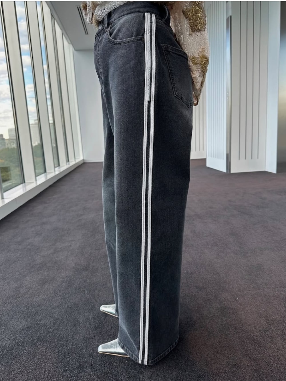 ブラック系のデニムパンツ、ホワイト系のTシャツ/カットソー、シルバー系のパンプスを着用したレディースの冬コーディネートの3枚目の写真